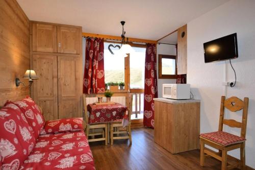 un salon avec un canapé rouge et une télévision dans l'établissement Résidence Les Hameaux I - Studio 3/4 pers - LES HAMEAUX I PLAGNE VILLAGES MAE-9094, à Aime La Plagne