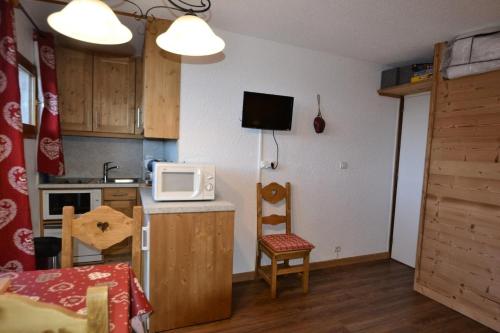 une petite cuisine avec une table et un micro-ondes dans l'établissement Résidence Les Hameaux I - Studio 3/4 pers - LES HAMEAUX I PLAGNE VILLAGES MAE-9094, à Aime La Plagne