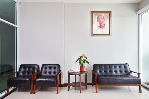 two black leather chairs and a table in a room at Rangh Place in Ban Map Samet Daeng