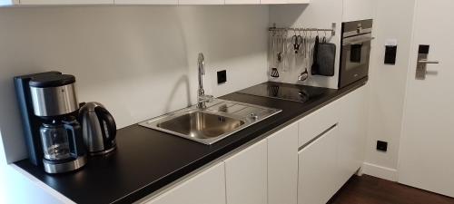 a kitchen counter with a sink and a coffee maker at Hotelapartment Meerlust in Cuxhaven