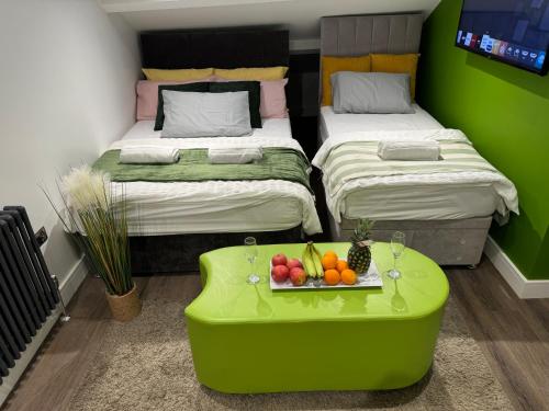 a room with two beds and a table with fruit on it at Southgate Luxury Apartments-Jaquzzi Bath-Private Parking- 2 Min M62 in Elland