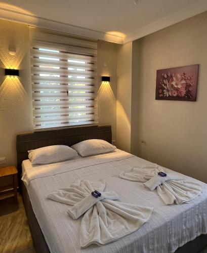 a bedroom with a bed with towels on it at Ayvalık Akan Pansiyon in Ayvalık