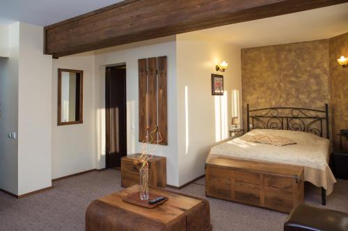 a bedroom with a bed and a table in a room at La Bucovineanca in Strîmtura