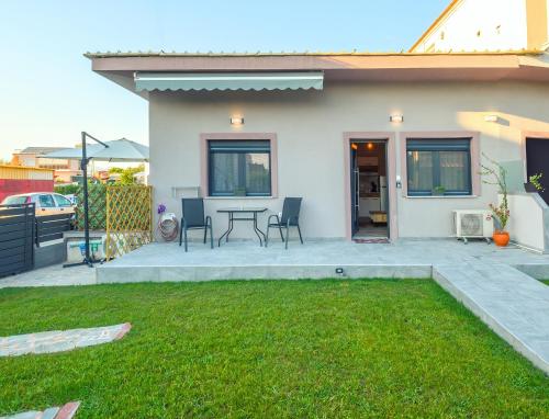 a patio with a table and chairs in front of a house at Hara Apartments in Chrysoupolis