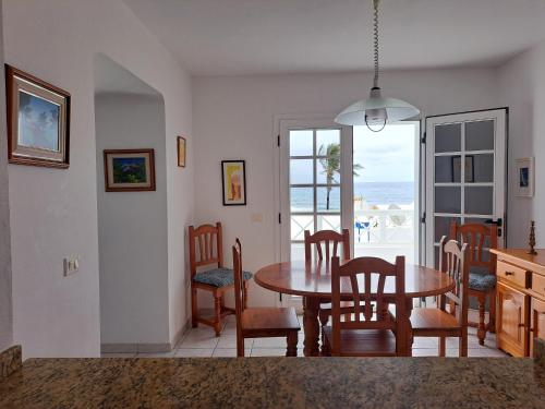 un comedor con mesa y sillas y el océano en Casa La Marea, en Arrieta