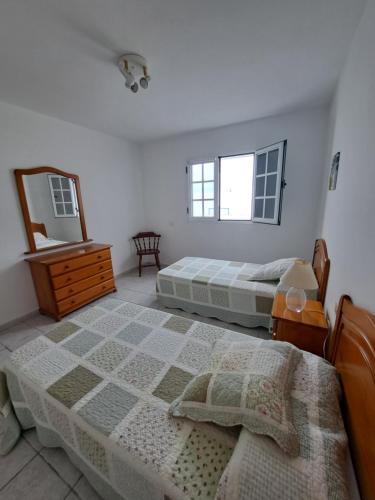 1 dormitorio con 2 camas, tocador y espejo en Casa La Marea, en Arrieta