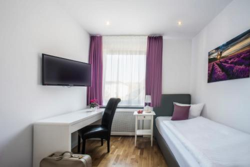 ein Hotelzimmer mit einem Schreibtisch und einem Bett in der Unterkunft Hotel Storchen in Ravensburg