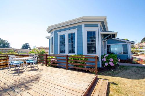 a house with a deck with a table and chairs at Edgewater Beach Inn in Santa Cruz