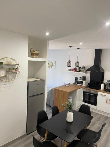 une cuisine avec une table et des chaises dans une pièce dans l'établissement Charmant Appart clim 6 pers, Sorgues Vaucluse 2, à Sorgues