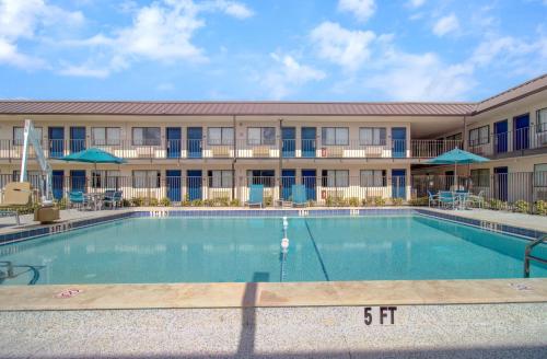 a swimming pool in front of a building at Motel 6-Venice, FL in Venice