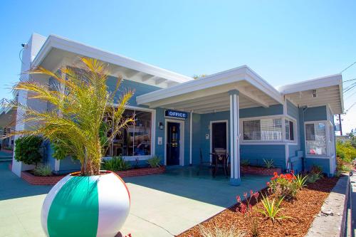 a blue building with a plant in a large vase at Edgewater Beach Inn in Santa Cruz
