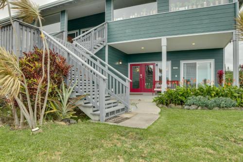 a green house with a staircase and a red door at The Aloha Green House Retreat with Ocean Views! in Naalehu