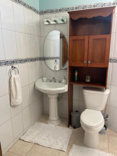 a bathroom with a toilet and a sink at Ocean Breeze Comfort in East End