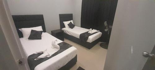 a room with two beds and a door open at Prasad Apartments in Labasa