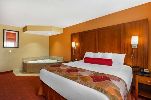 a hotel room with a large bed and a bath tub at Best Western Plus Georgetown Corporate Center Hotel in Georgetown