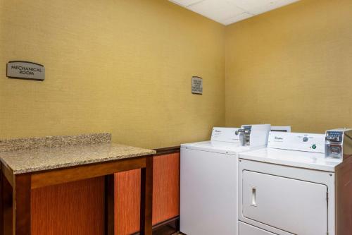 a laundry room with a washing machine and a counter at Best Western Plus Georgetown Corporate Center Hotel in Georgetown
