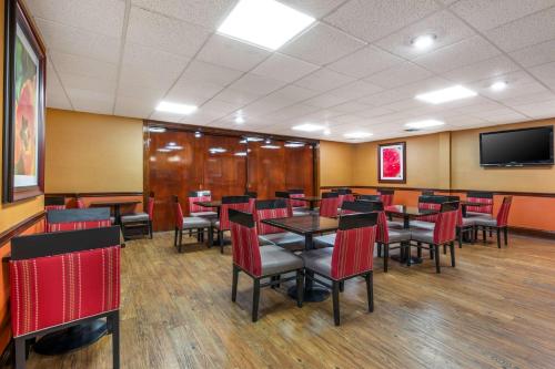 a dining room with tables and chairs and a flat screen tv at Best Western Plus Georgetown Corporate Center Hotel in Georgetown