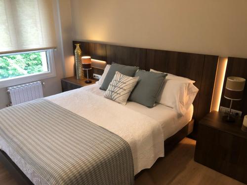 a bedroom with a large bed with blue and white pillows at Alojamiento Mar y Bienestar in Laredo