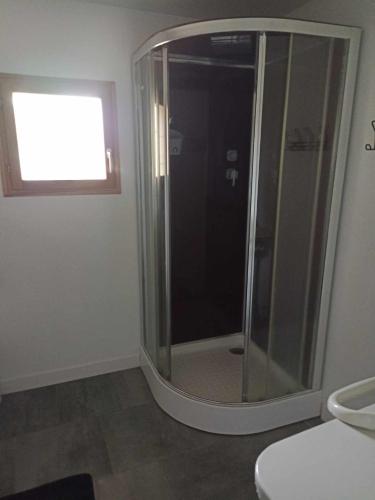 a bathroom with a glass shower with a window at maison 2 chambres 4 lits 15mn Aéroport de Beauvais 5mn du château de la trye in Hermes