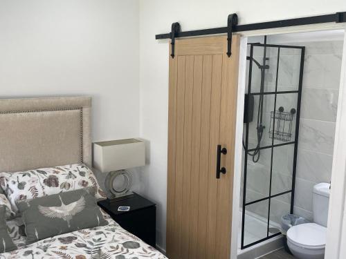 a bedroom with a bed and a door with a toilet at The Old Stable, Rustic Charm Modern Comforts in Gorfield