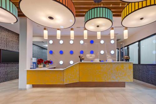 a lobby with a yellow counter and blue accents at GLō Best Western Kanata Ottawa West in Ottawa