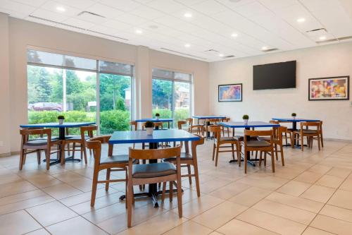 a waiting room with tables and chairs and a flat screen tv at GLō Best Western Kanata Ottawa West in Ottawa