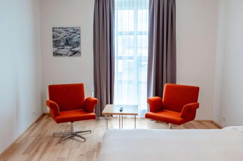 a bedroom with two chairs and a bed and a window at Park Inn by Radisson Reykjavik Keflavík Airport in Keflavík