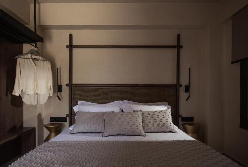 a bedroom with a large bed with white sheets and pillows at Pournari Mountain Rooms in Toroni