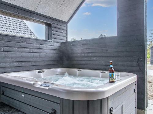 a hot tub with a bottle of beer in it at 8 person holiday home in Rømø-By Traum in Kongsmark