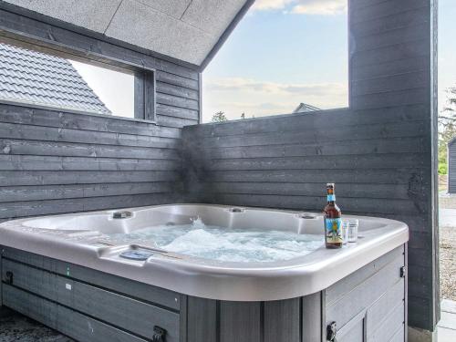 a hot tub with a bottle of beer in it at 8 person holiday home in Rømø in Kongsmark
