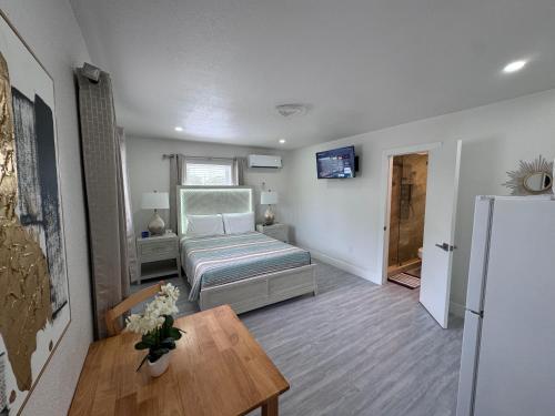 a small room with a bed and a table and a refrigerator at Stylish Studio Apartment By Miami International Airport in Miami