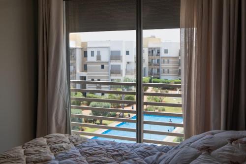 a bedroom with a window with a view of a pool at Sublime duplex, piscine, parking in Bouskoura