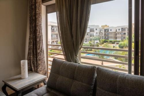 a living room with a window with a view of a pool at Sublime duplex, piscine, parking in Bouskoura