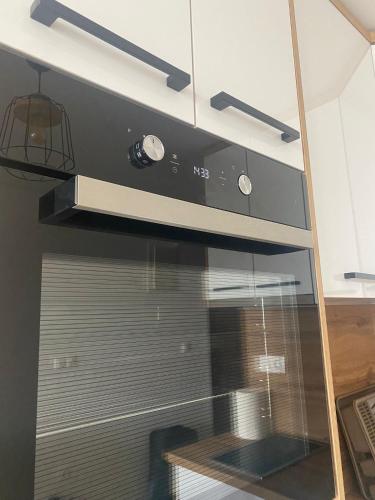 a kitchen with a microwave and a stove at Apartman Green in Šišava