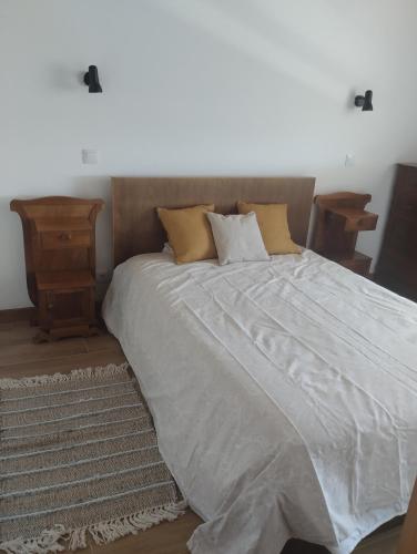 a bedroom with a large bed with a wooden headboard at Casa da Tia Avelina in Angra do Heroísmo
