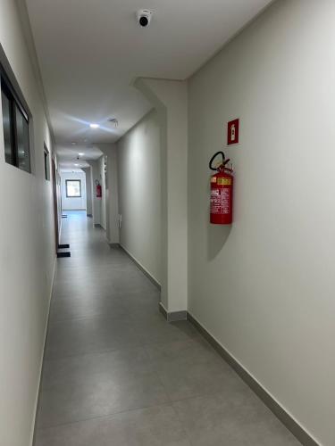 a hallway in a building with a fire extinguisher on the wall at Loft Solaris Apart Hotel - Suíte - Apt. N.105 in João Câmara