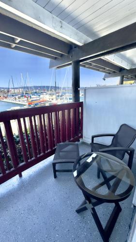 a patio with a glass table and chairs on a balcony at Marina Village Inn in Alameda
