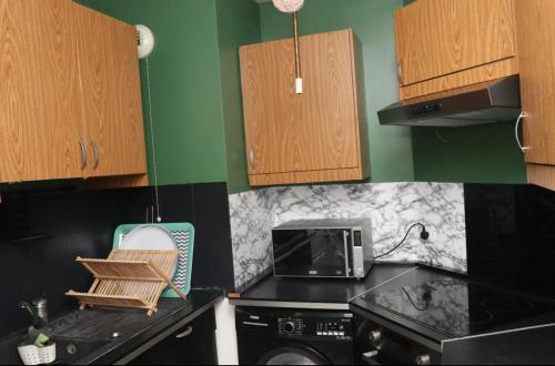 une cuisine avec une cuisinière et un micro-ondes dans l'établissement Appartement 5 étoiles, à Villepinte