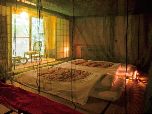 a bed in a room with a glass wall at Motoyu Ishiya in Kanazawa