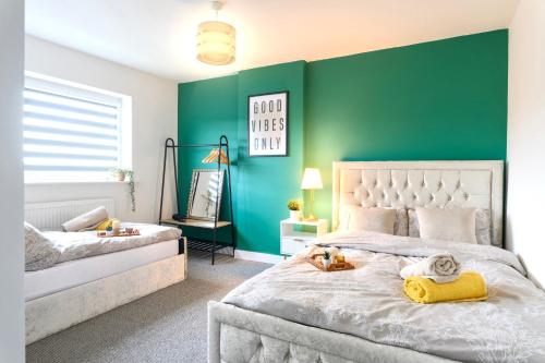a bedroom with two beds and a green wall at A Luxurious Home with Hot Tub and Man Cave! 9ppl in Whiston