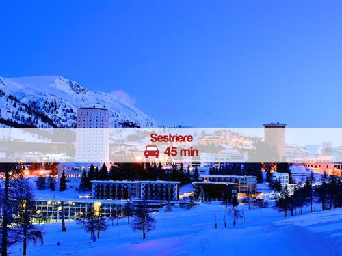 a large building in the snow at night at Hotel Villa Glicini in Pinerolo