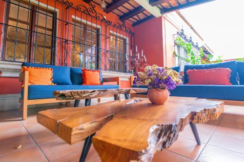 a room with couches and a table with flowers on it at Santa Margarita in Antigua Guatemala