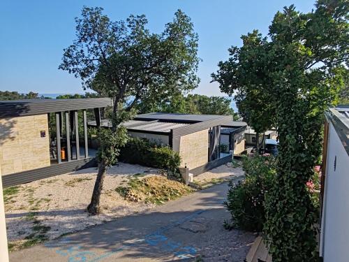 a building with a black roof and a tree at Annika Mar in Selce
