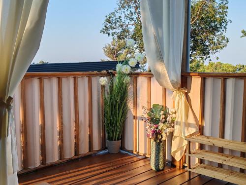 a balcony with a wooden deck with vases of flowers at Annika Mar in Selce