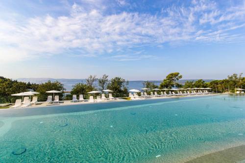 a large swimming pool with chairs and umbrellas at Annika Mar in Selce