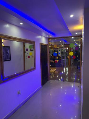 a purple room with a mirror and a glass door at 24-Hour Electricity An Entire Stylish 4-Bedroom Bungalow in Akure
