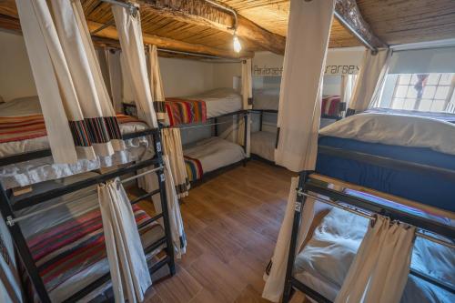 a room with three bunk beds in a house at Puna Hostel in San Pedro de Atacama