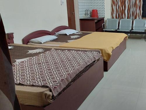 グルヴァイアールにあるAdhithya Apartmentsの部屋に椅子が置かれたベッドが2つ