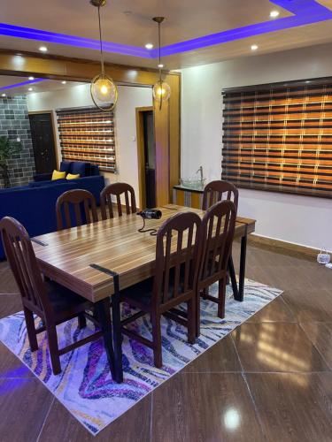 a wooden dining room table and chairs in a room at 24-Hour Electricity An Entire Stylish 4-Bedroom Bungalow in Akure