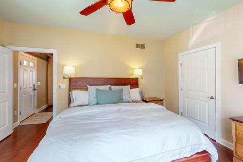 a bedroom with a large white bed with a ceiling fan at Adventure Annapolis in Annapolis